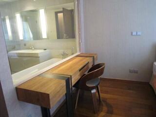 Modern bedroom with a wooden desk and chair next to an attached bathroom