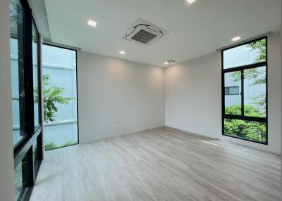 Spacious room with large windows and wooden flooring