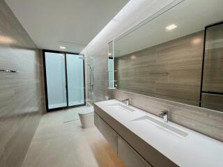 Modern bathroom with double sink and walk-in shower