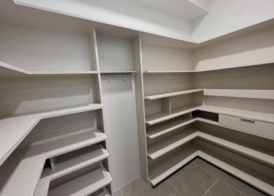 Spacious walk-in closet with built-in shelves and drawers