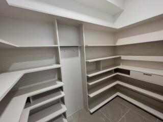 Spacious walk-in closet with built-in shelves and drawers