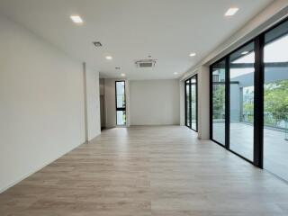 Spacious living room with large windows and sliding glass doors.