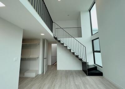 Modern living area with high ceilings and staircase