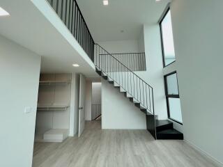 Modern living area with high ceilings and staircase