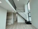 Modern living area with high ceilings and staircase