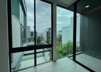 Modern balcony with large glass doors and surrounding buildings view