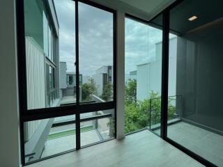 Modern balcony with large glass doors and surrounding buildings view