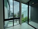 Modern balcony with large glass doors and surrounding buildings view