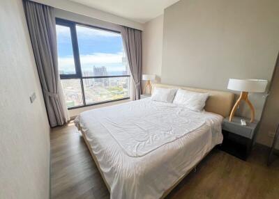 bedroom with a large window and city view