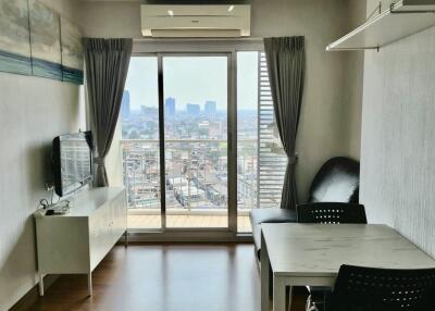 Living room with city view, furniture, and large window.