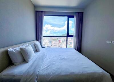 Modern bedroom with a large window offering a city view