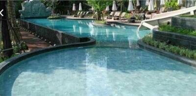 Swimming pool area with slide and loungers