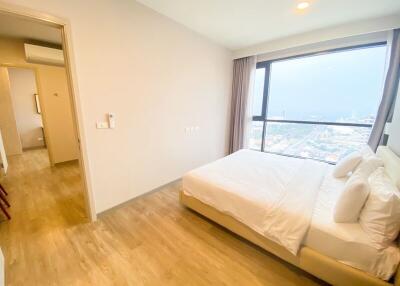 Well-lit bedroom with a large window and city view