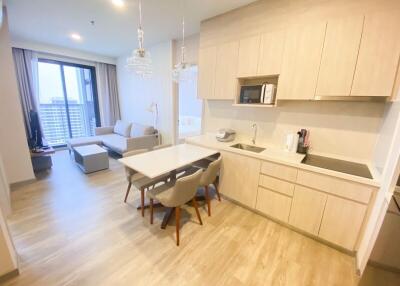 Modern kitchen and living area with wooden flooring and natural light