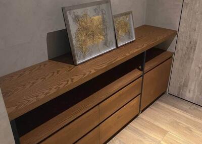 Bedroom with wooden dresser and framed artworks