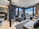 Modern living room with adjoining bedroom, desk setup, and city view