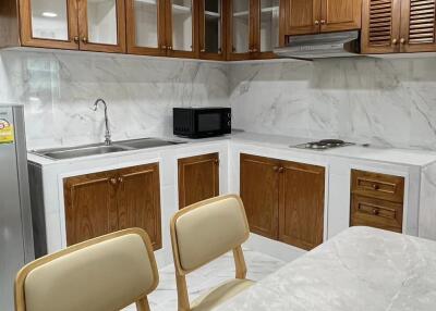 Modern kitchen with marble countertops and wooden cabinets