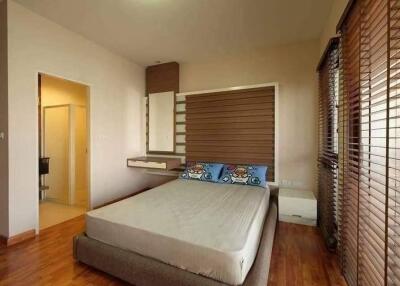 Modern bedroom with large bed and wooden blinds