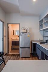 Modern kitchen with stainless steel appliances and doorway to bathroom