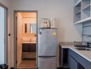 Modern kitchen with stainless steel appliances and doorway to bathroom