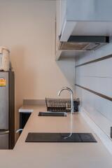 Modern kitchen with stovetops, sink, and cupboard