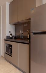 Modern kitchen with brown cabinets, refrigerator, and appliances