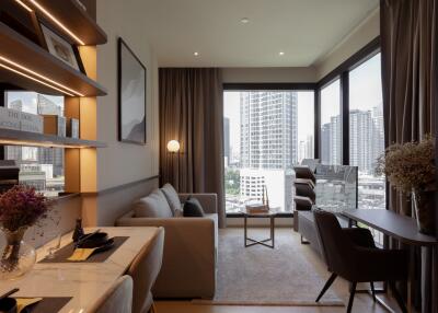 Modern living room with large windows, a sofa, table, and desk area.