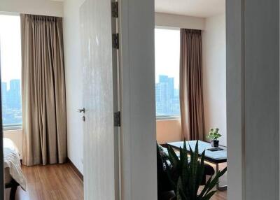 View into a bedroom with wooden flooring and large windows