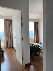 View into a bedroom with wooden flooring and large windows