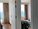 View into a bedroom with wooden flooring and large windows