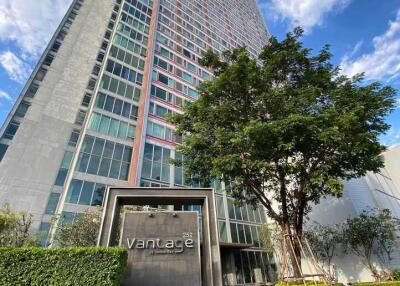 Tall residential building with a lush green surrounding