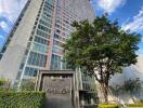 Tall residential building with a lush green surrounding