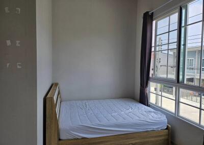 Small bedroom with window and simple furniture