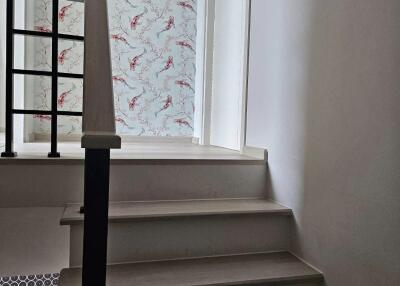 Stairway leading to upper floor with patterned wallpaper