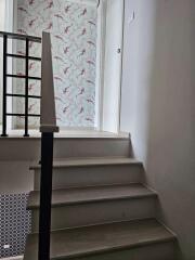 Stairway leading to upper floor with patterned wallpaper