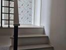 Stairway leading to upper floor with patterned wallpaper