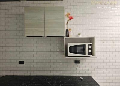 Modern kitchen with microwave and tile backsplash