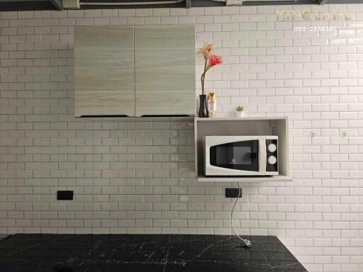 Modern kitchen with microwave and tile backsplash