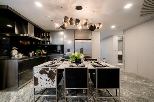 Modern kitchen with dining area featuring a stylish chandelier