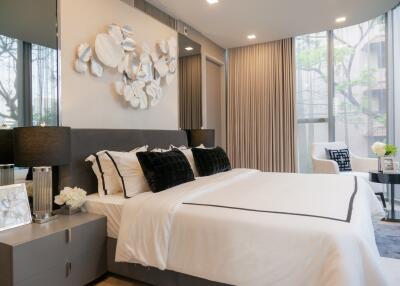 Modern bedroom with king-size bed, contemporary decor, and large windows