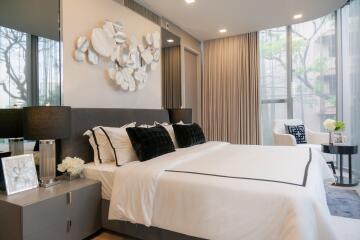 Modern bedroom with king-size bed, contemporary decor, and large windows