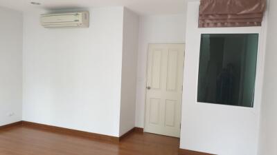 Interior of an empty room with wooden floor and air conditioning unit