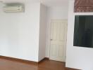 Interior of an empty room with wooden floor and air conditioning unit