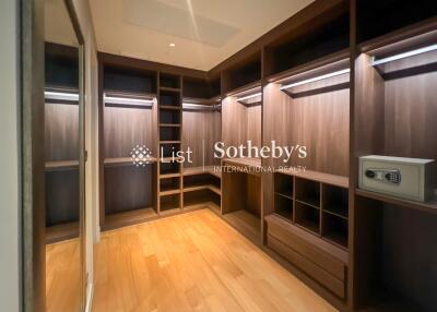 Modern walk-in closet with wooden shelves and built-in lighting