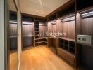 Modern walk-in closet with wooden shelves and built-in lighting