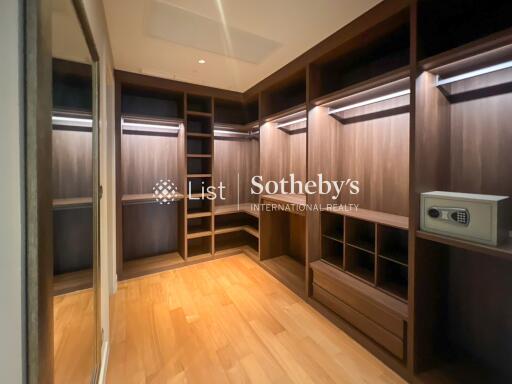 Modern walk-in closet with wooden shelves and built-in lighting