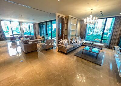 Spacious living room with modern furniture and large windows providing city views