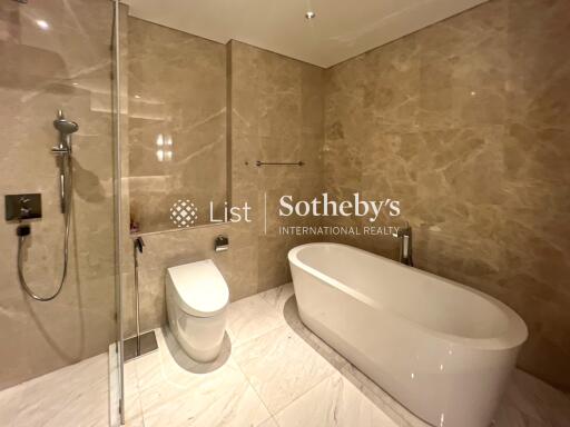 Luxurious bathroom with modern fixtures including a white bathtub and a shower area