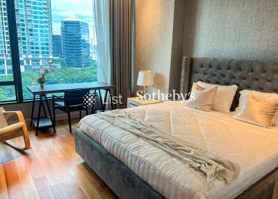 luxurious bedroom with a large bed, desk, and city view