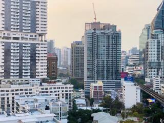 City skyline view featuring multiple high-rise buildings and a crane in the background